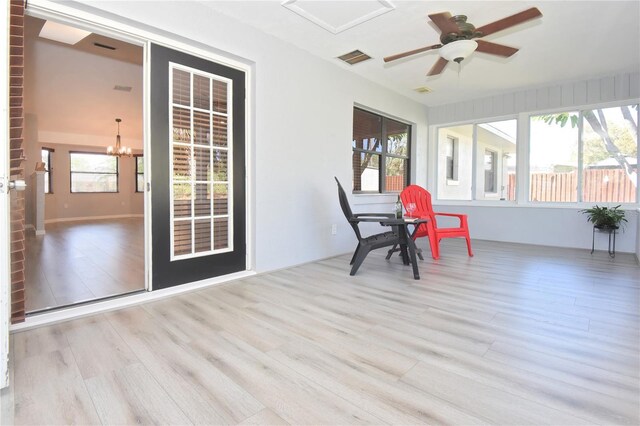 sunroom with visible vents and ceiling fan with notable chandelier