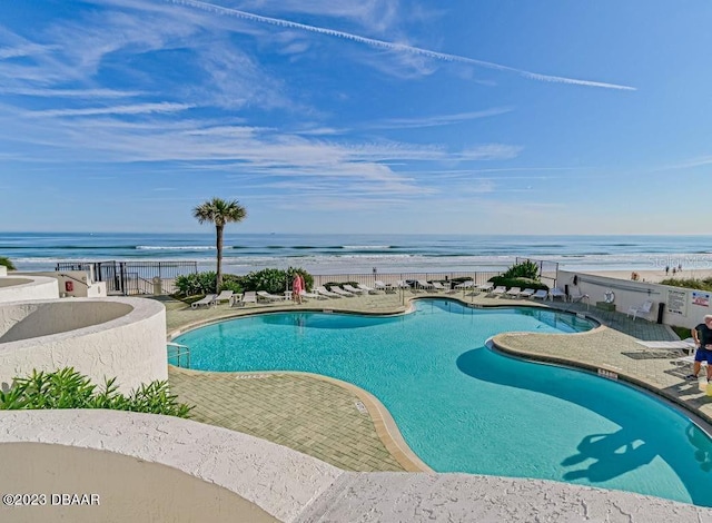 pool with a patio area and a water view