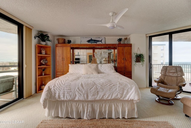 bedroom with a wall of windows, carpet flooring, access to exterior, and a textured ceiling