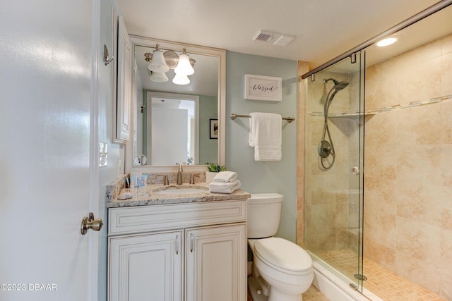 full bathroom with vanity, toilet, visible vents, and a stall shower