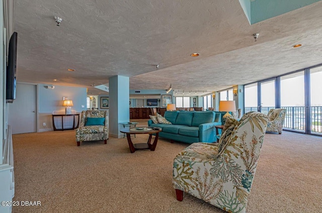 living room with floor to ceiling windows, carpet, and a textured ceiling