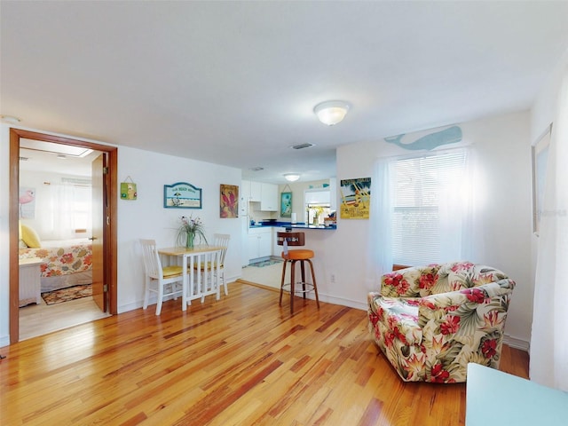 living area featuring light wood finished floors and baseboards