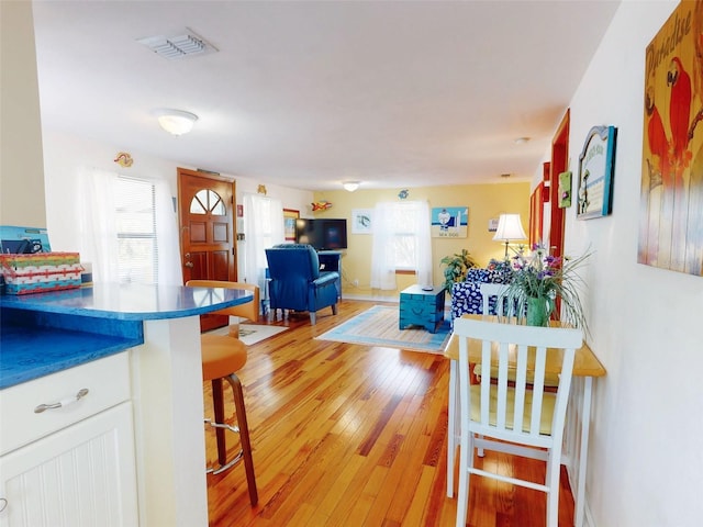 dining room with light wood-style floors and visible vents