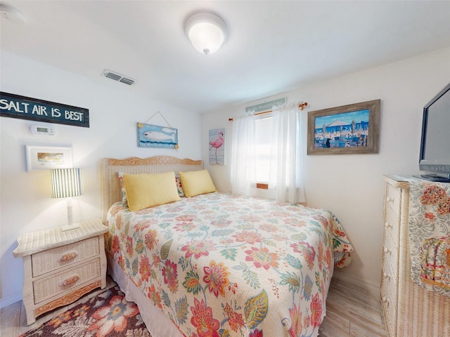 bedroom with visible vents and wood finished floors