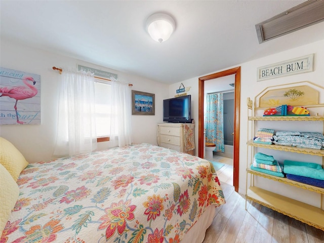 bedroom featuring visible vents and wood finished floors