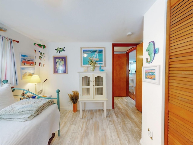 bedroom with wood finished floors and a closet