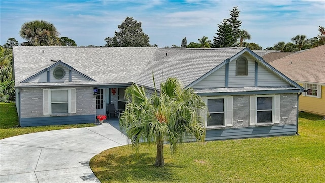 view of front of house featuring concrete driveway, brick siding, a front yard, and a shingled roof