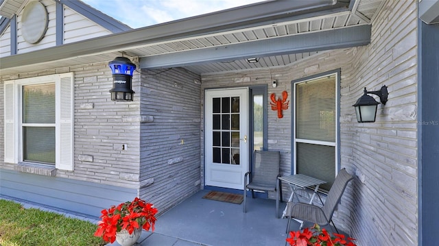 entrance to property featuring brick siding