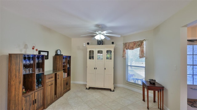 foyer featuring baseboards and ceiling fan