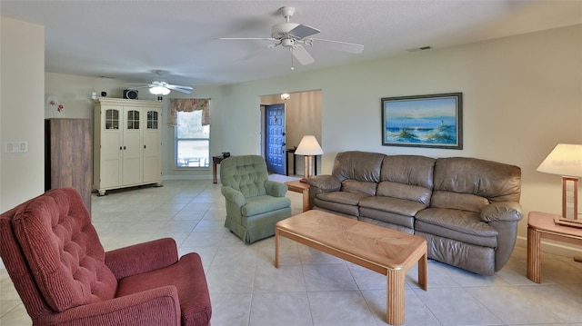 living area featuring light tile patterned floors, visible vents, and a ceiling fan