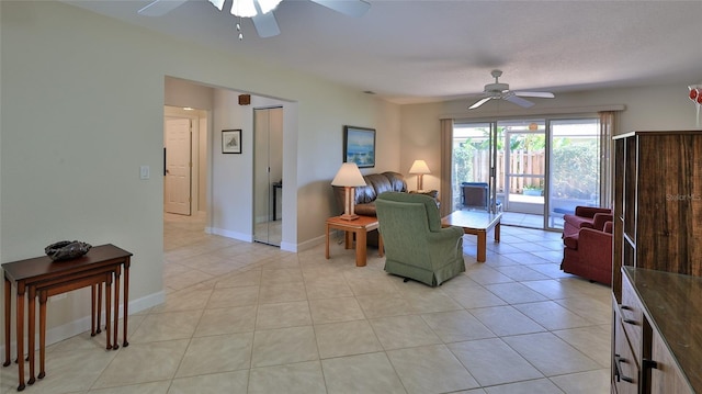 living room with light tile patterned flooring, baseboards, and ceiling fan