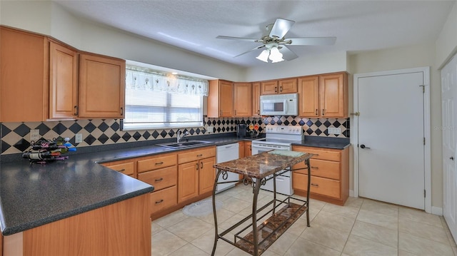 kitchen with ceiling fan, white appliances, dark countertops, and a sink