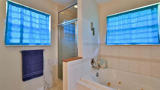 bathroom with a jetted tub and a stall shower