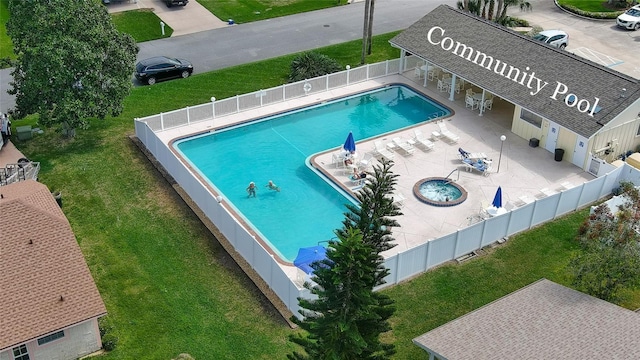 community pool with a patio area, a lawn, and a fenced backyard