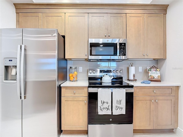 kitchen featuring light countertops, appliances with stainless steel finishes, and light brown cabinetry