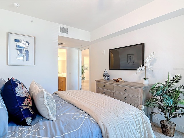 bedroom with visible vents, connected bathroom, and carpet