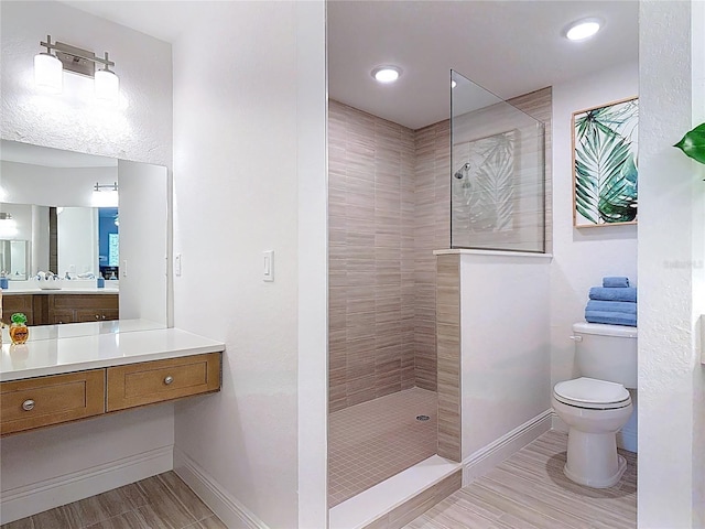 full bath featuring vanity, toilet, baseboards, and walk in shower