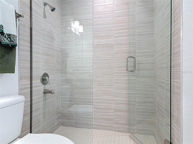 bathroom featuring a shower stall and toilet