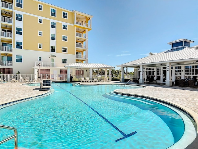 community pool featuring a ceiling fan, a patio, and fence