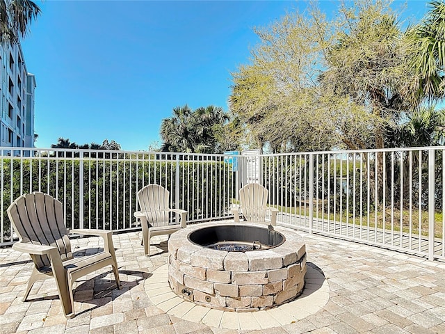 view of patio / terrace with an outdoor fire pit and fence