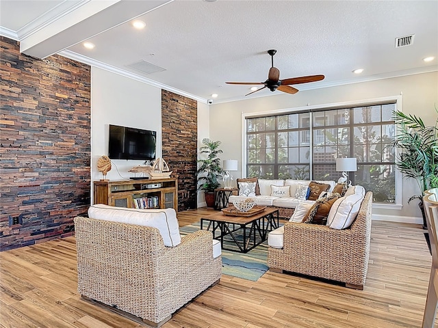 living area featuring visible vents, plenty of natural light, light wood-style floors, and ceiling fan