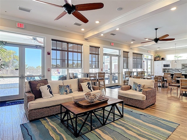 living room featuring visible vents, ceiling fan, ornamental molding, french doors, and wood finished floors