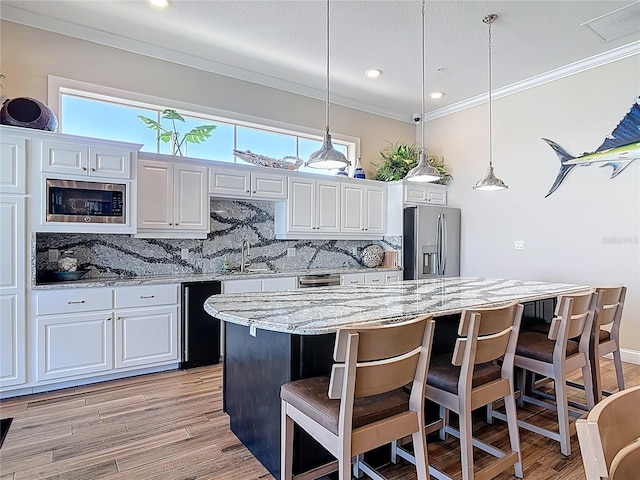 kitchen with backsplash, appliances with stainless steel finishes, crown molding, and a sink