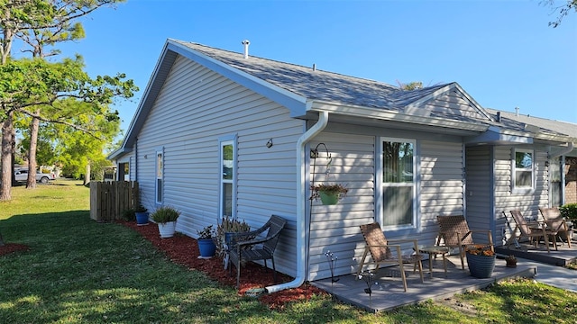 919 Fairvilla Dr, New Smyrna Beach, FL 32168 - back of property with a patio, a lawn, and a shingled roof