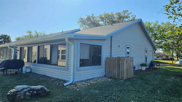 919 Fairvilla Dr, New Smyrna Beach, FL 32168 - view of home's exterior with a yard, a sunroom, and a shingled roof