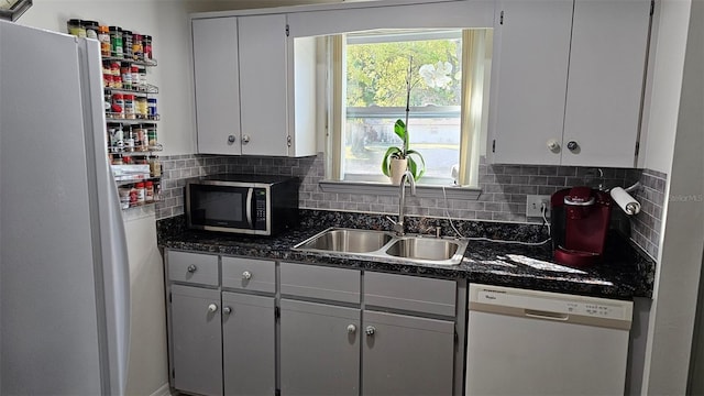 919 Fairvilla Dr, New Smyrna Beach, FL 32168 - kitchen with a sink, decorative backsplash, white appliances, and dark countertops