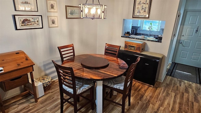 919 Fairvilla Dr, New Smyrna Beach, FL 32168 - dining room with an inviting chandelier, wood finished floors, and baseboards