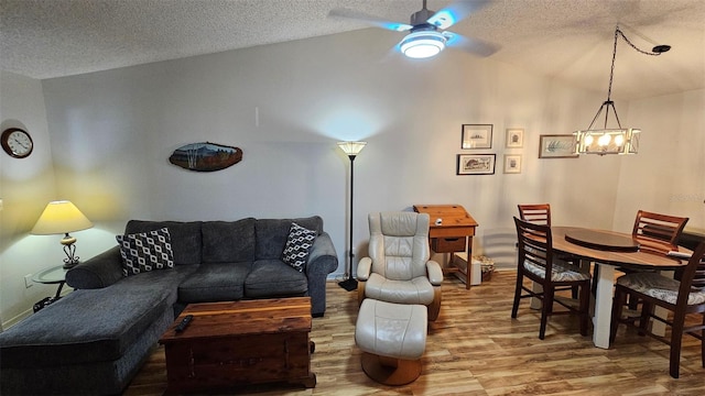 919 Fairvilla Dr, New Smyrna Beach, FL 32168 - living area featuring a textured ceiling, wood finished floors, vaulted ceiling, and ceiling fan with notable chandelier