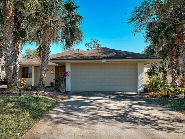 168 Turnberry Cir, New Smyrna Beach, FL 32168 - ranch-style house with stucco siding, a garage, and driveway