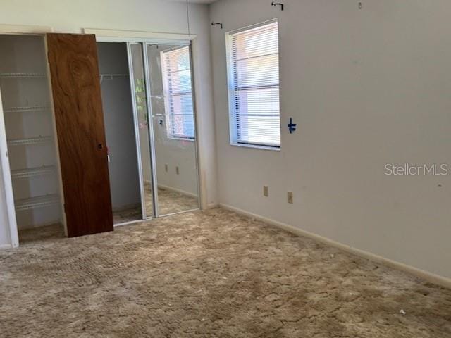 unfurnished bedroom with baseboards and carpet