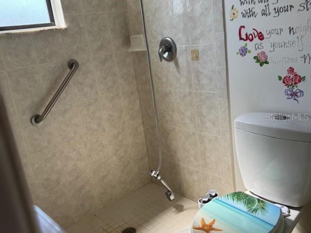 full bath featuring toilet and a tile shower