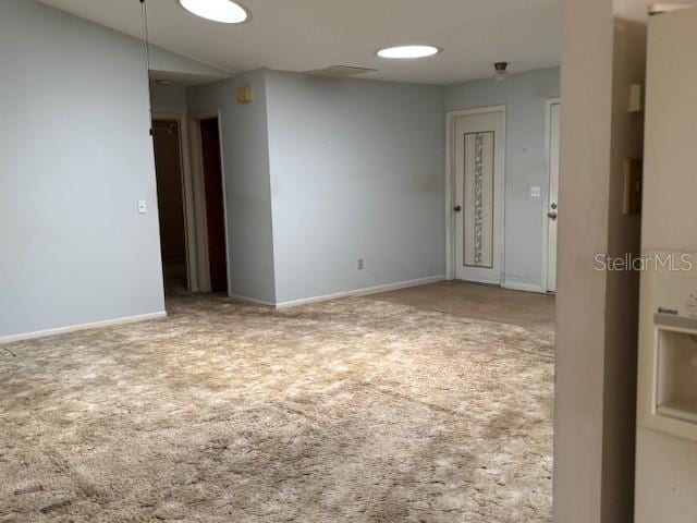carpeted spare room with baseboards