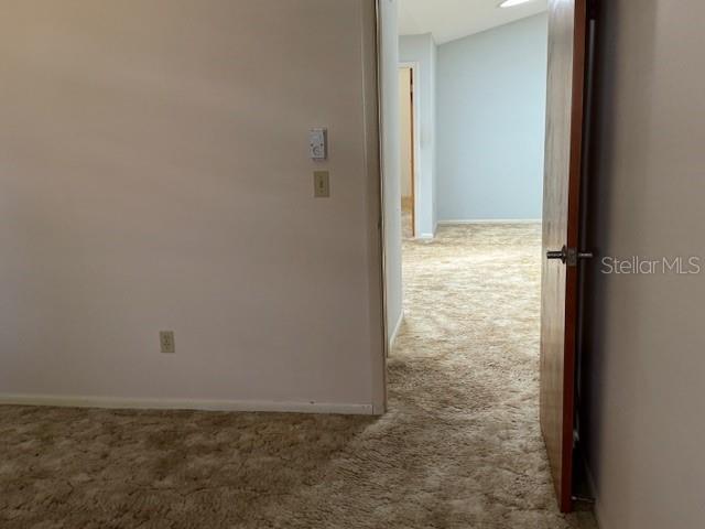 hallway with carpet floors and baseboards