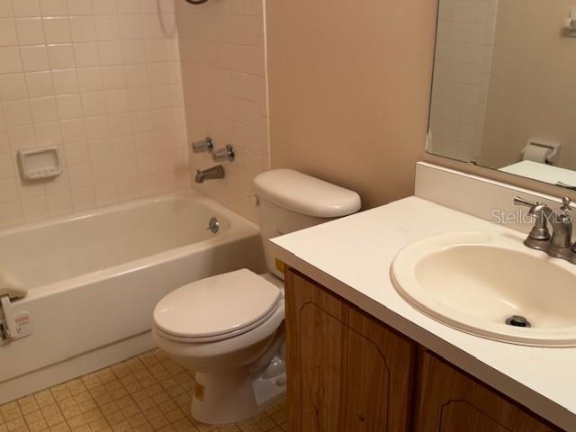 bathroom featuring toilet, vanity, and bathing tub / shower combination