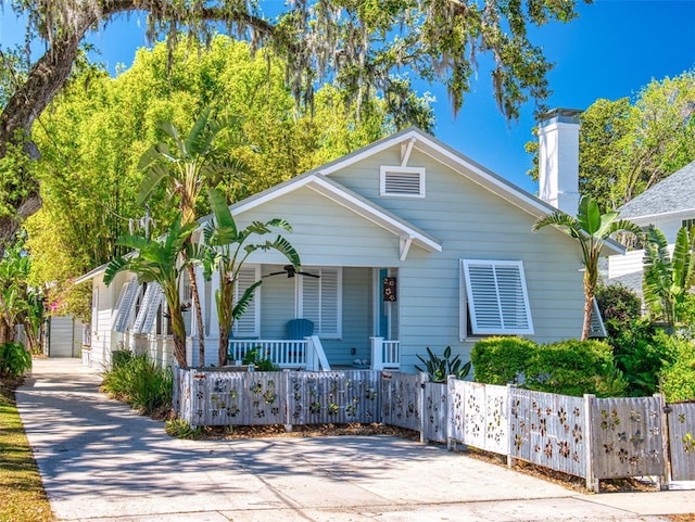536 Faulkner St, New Smyrna Beach, FL 32168 - bungalow with a fenced front yard, ceiling fan, a porch, a garage, and a chimney