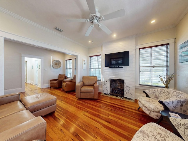 536 Faulkner St, New Smyrna Beach, FL 32168 - living area featuring a fireplace, ceiling fan, light wood-style floors, and crown molding