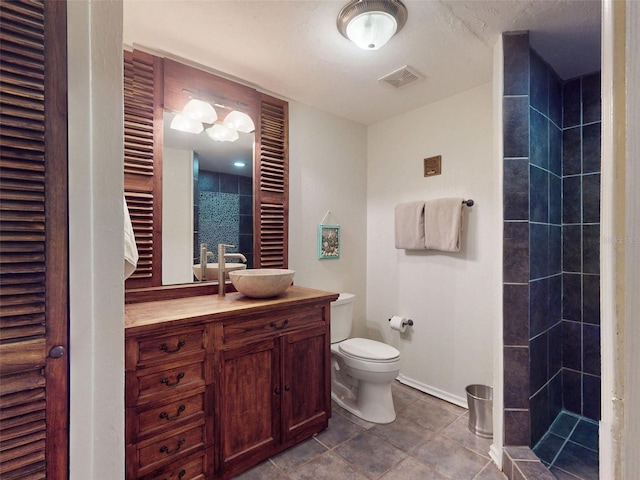 536 Faulkner St, New Smyrna Beach, FL 32168 - bathroom with vanity, toilet, baseboards, visible vents, and tiled shower