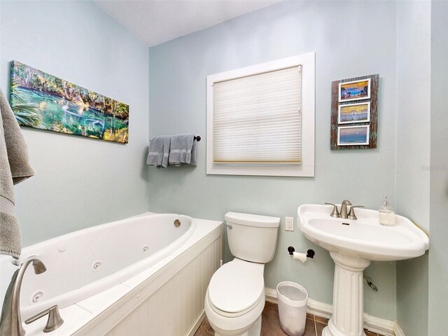 536 Faulkner St, New Smyrna Beach, FL 32168 - bathroom featuring toilet, a whirlpool tub, and baseboards