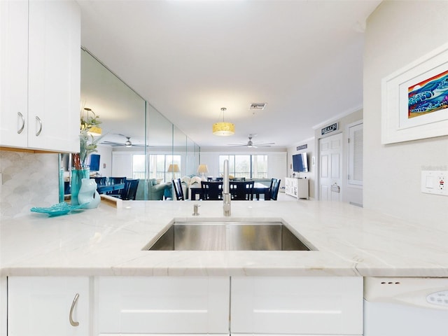 2700 N Peninsula Ave Unit 114, New Smyrna Beach, FL 32169 - kitchen with white cabinets, a sink, light stone counters, dishwasher, and a ceiling fan