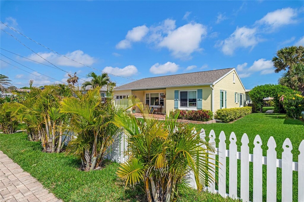 view of front of home with fence and a front lawn