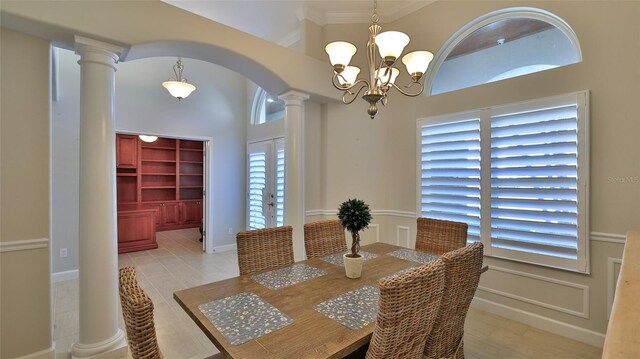 2904 Palma Ln, New Smyrna Beach, FL 32168 - dining space featuring ornate columns, arched walkways, a chandelier, crown molding, and a towering ceiling