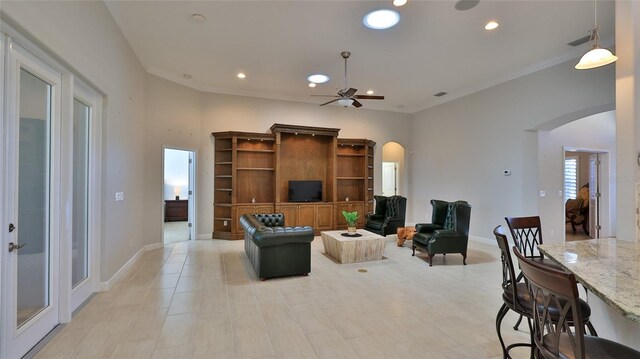 2904 Palma Ln, New Smyrna Beach, FL 32168 - living room featuring arched walkways, a ceiling fan, recessed lighting, baseboards, and crown molding