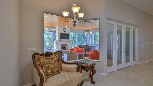 2904 Palma Ln, New Smyrna Beach, FL 32168 - sitting room featuring a fireplace, a chandelier, baseboards, and tile patterned flooring