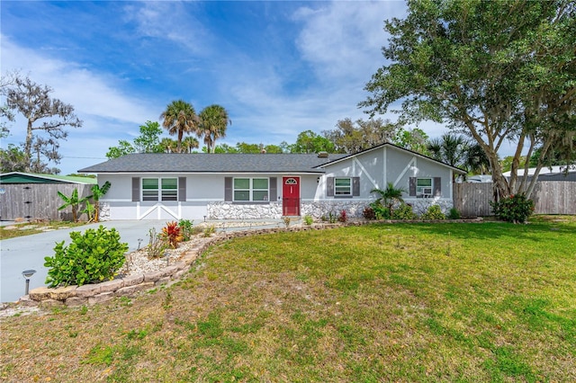 ranch-style home with a front yard, driveway, stucco siding, and fence