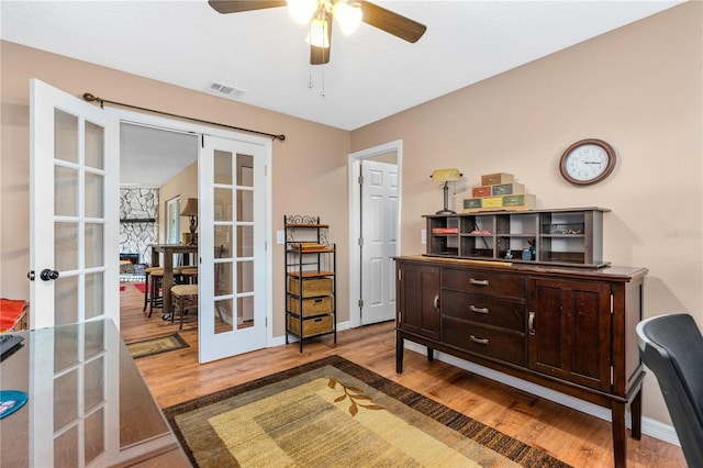 sitting room with french doors, wood finished floors, a ceiling fan, and visible vents