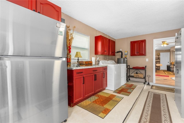 kitchen with freestanding refrigerator, washer / dryer, ceiling fan, and a textured ceiling